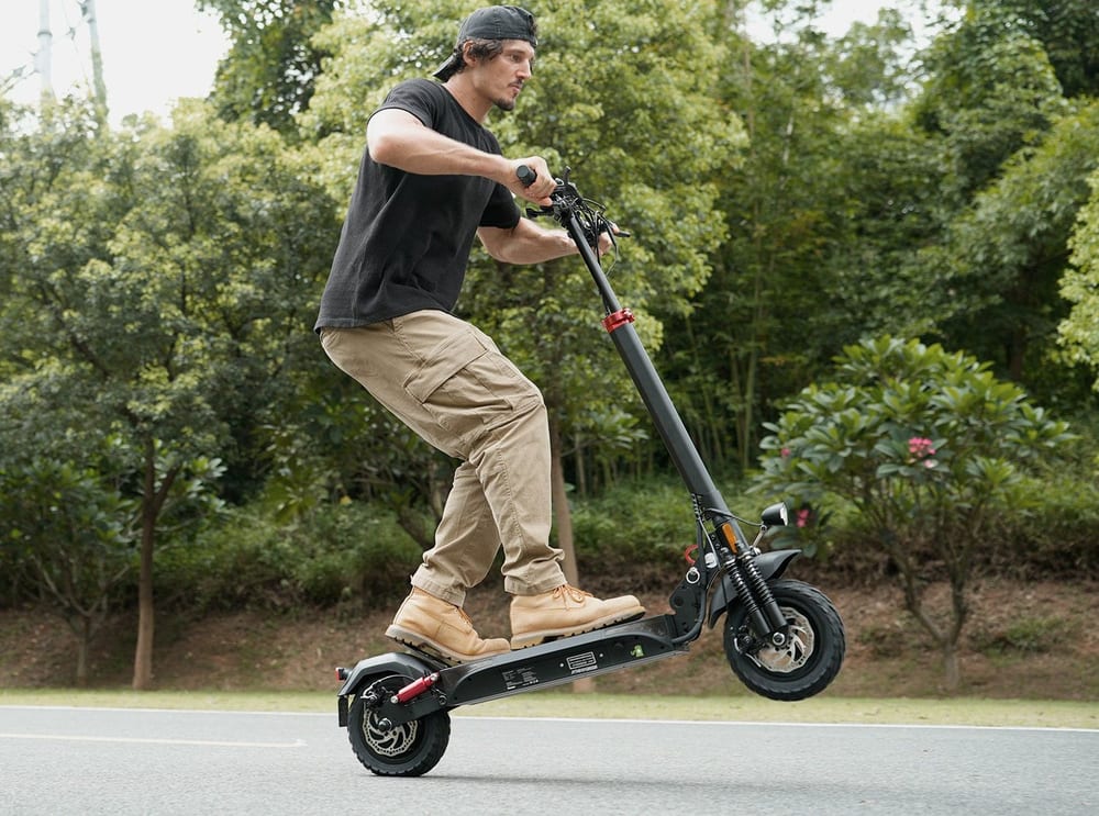 Vezető áll az iHoverboard T4 rolleren egy aszfaltozott úton
